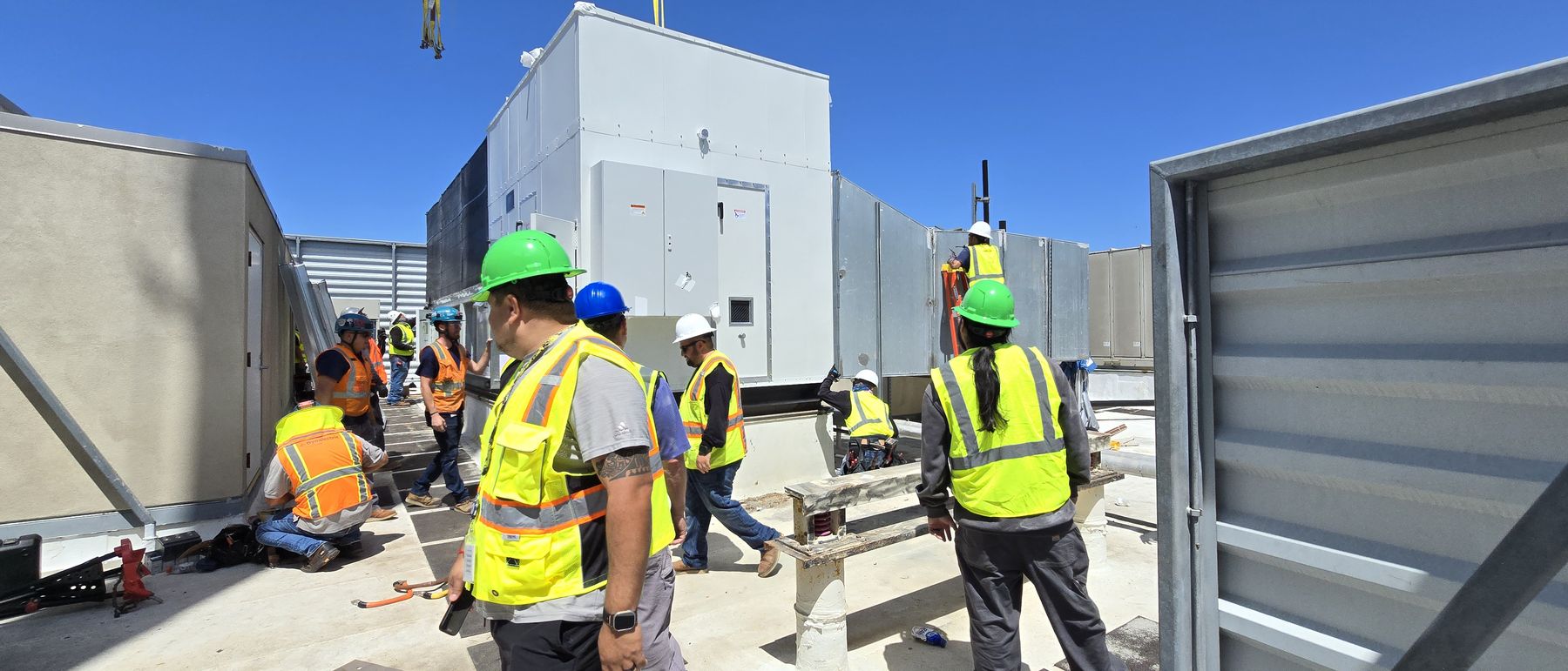 Crew walking between installed units on a completed building roof