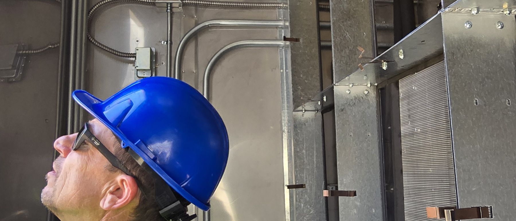 Technician inspecting the internal ductwork and connections of a replacement unit