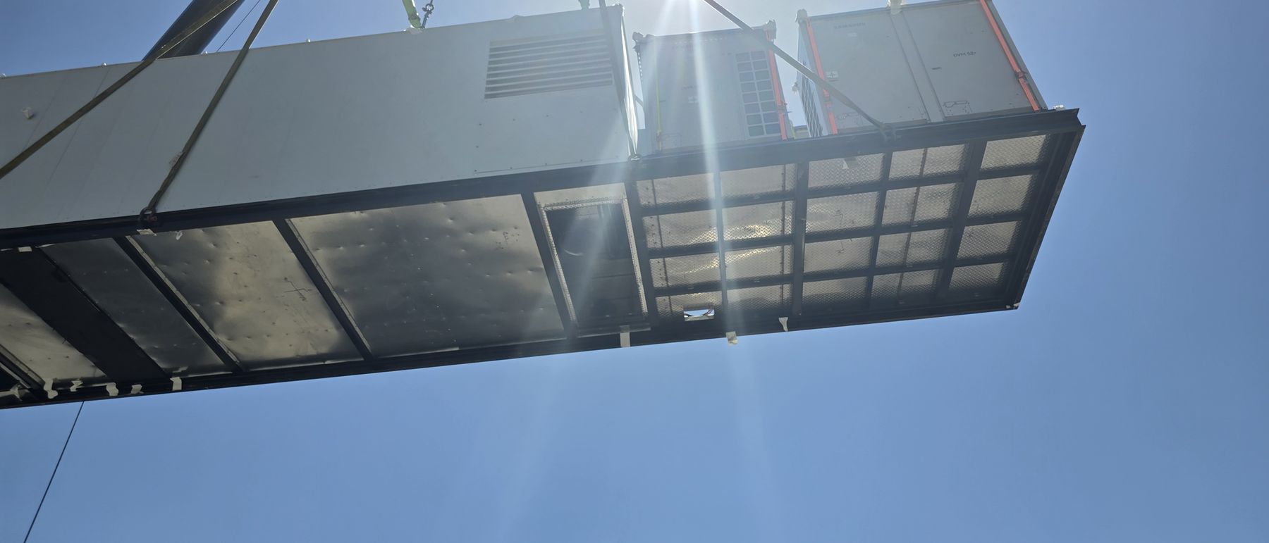 Replacement unit suspended from the crane above the roof line
