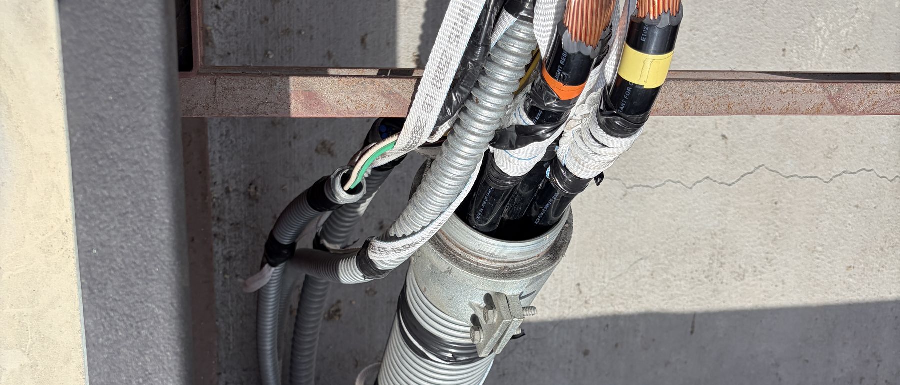 Existing building feeder conductors landed at the roof penetration, reused without upsizing